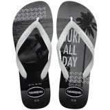 Sandalias Havaianas Top Athletic para hombre, en color gris y negro, con tiras blancas de diseño texturizado. La plantilla cuenta con un estampado gráfico que incluye la leyenda 'Surf All Day', siluetas de una palmera y una persona haciendo surf, y motivos de olas.