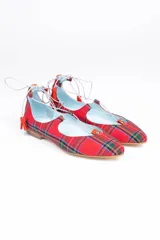 Bailarinas rojas con estampado tartán, anudadas al tobillo con cordones blancos y borlas decorativas.
