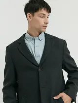 Sobretodo 3/4 de paño, color gris oscuro, con cuello solapa, cierre frontal de botones, manga larga y bolsillos laterales de ribete.