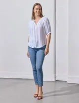 Blusa color fucsia con estampado de rayas verticales y flores, cuello redondo con escote en V y mangas cortas abullonadas.