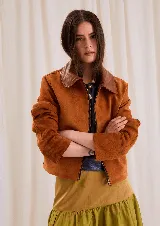 Chaqueta de gamuza color óxido, con cuello clásico en tono marrón más oscuro y cierre frontal metálico.