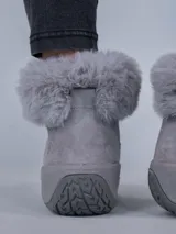 Botas de estilo montañés color gris, confeccionadas en cuero y poliéster. Presentan cuello con forro de piel sintética, ajuste mediante cordones con ganchos metálicos y suela de goma con tecnología Spinal Flex para mayor confort.