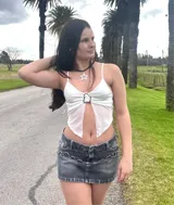 Top negro con breteles finos, escote en forma de corazón y detalle de abertura en el abdomen. Incluye un cinturón de cadena plateada.