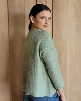 Sweater de punto color verde claro con textura tipo waffle, cuello redondo y mangas 3/4.