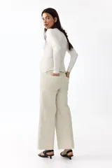 Jean tobillero de denim de algodón con leve stretch, diseño de pierna ancha y corte holgado. Modelo de tiro alto con panel de punto elástico para maternidad y pliegues en las piernas.