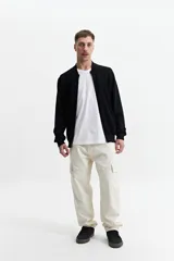 Campera tejida de punto color beige, con cuello rib, puños y bolsillos laterales.