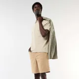 Bermuda ligera color beige, de corte clásico con bolsillos laterales y trabillas para cinturón.