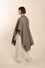 Ruana de lana fina sin teñir, con textura acanalada y terminaciones tejidas a crochet hechas a mano.