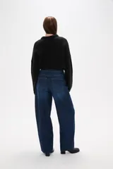 Pantalon jean de corte barrel y tiro medio, en color negro, con diseño de pierna ancha y estructura rígida.