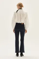 Jean de mezclilla azul marino, tiro medio, con silueta ligeramente acampanada desde la rodilla.