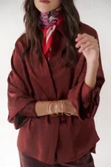 Camisa azul marino de satén con cuello clásico, cierre frontal con botones y mangas largas con puños abotonados.