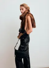 Bolso tipo bandolera de color negro, con diseño estructurado de media luna, asa ajustable y detalles metálicos dorados.