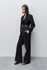 Blazer sastrero negro de silueta recta y calce relajado, con cuello con solapas, hombros levemente estructurados y bolsillos delanteros con vivo.