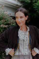 Chaqueta acolchada de algodón en color crudo, con diseño de matelassé, corte holgado, mangas largas y bolsillos frontales tipo parche.