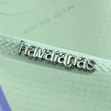 Ojotas Havaianas modelo Slim Point, con base color violeta claro y borde lateral en tono rojizo. Presentan tiras finas con textura y logo de la marca en relieve.