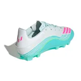 Championes de fútbol Adidas F50 Messi Club, diseñados para terreno firme y césped artificial. Presentan un diseño aerodinámico en color blanco con degradado en turquesa y detalles en fucsia y amarillo neón.