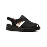 Sandalia casual Korium Confort modelo Jadiya, de color negro con detalles perforados en la capellada y tira ajustable con velcro en el talón. Posee suela gruesa y plantilla de cuero.