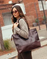 Bolso tipo tote de cuero vacuno color chocolate, con textura efecto cocodrilo en la parte superior y base lisa. Cuenta con doble asa de hombro y cierre superior.