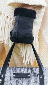 Guantes sin dedos confeccionados en cuero negro con interior y detalles de corderito sintético.