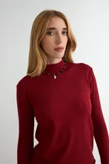 Polera de tejido de punto fino color bordó, con cuello alto y mangas largas.