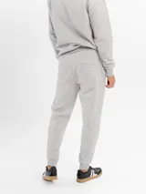 Pantalón de jogging de felpa color gris melange, con corte ajustado, cintura elástica con cordón de ajuste y bolsillos laterales con cierre.
