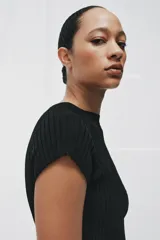 Top negro de punto rib con cuello redondo, manga corta y diseño de bajo asimétrico.
