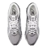 Championes urbanos New Balance modelo 204, color gris con detalles en blanco y negro. Confeccionados en malla técnica y refuerzos sintéticos, presentan el logo lateral característico de la marca y suela de goma con relieve.