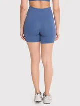 Calza corta tipo biker de tiro alto con pretina en V, color azul. Confeccionada en tejido técnico con bandas de silicona internas para mayor sujeción.