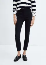 Pantalón skinny crop de tiro medio, color negro, de corte entallado y largo tobillero con trabillas en la cintura.
