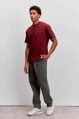 Pantalon de corte recto en color verde oliva, confeccionado en tejido de algodón con acabado ligeramente desgastado, cuenta con bolsillos laterales y cierre frontal.