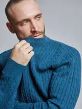 Sweater color beige con cuello redondo y tejido trenzado de ochos. Confeccionado en 60% algodón y 40% poliéster.