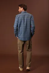 Camisa de hombre celeste con estampado de rayas horizontales en tonos azules y grises, de manga larga y cuello abotonado.