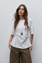 Remera de manga corta color blanco con cuello redondo y detalle de frunce lateral que aporta movimiento y una silueta entallada.