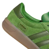 Championes Adidas Glenburn de color verde, confeccionados en gamuza con las clásicas tres tiras en los laterales en tono verde oscuro, suela de goma translúcida y detalles con el nombre del modelo y la marca en dorado.