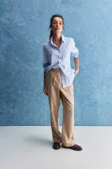 Pantalón recto color beige con cintura elástica, cordón ajustable y costuras frontales verticales.