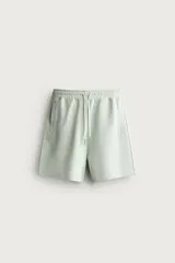 Bermuda estilo jogger de ajuste relajado, confeccionada en tejido interlock de algodón. Cuenta con cintura elástica ajustable con cordón, bolsillos frontales de vivo y diseño liso.