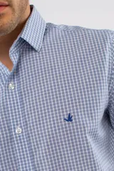 Camisa de manga larga con diseño de cuadros en tonos azules, blancos y negros. Presenta cuello clásico, cierre frontal con botones y logo bordado en el pecho. Corte semi slim.