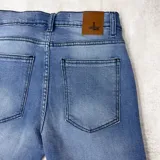 Bermuda de jeans celeste con roturas y dobladillo.
