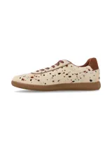 Sneaker deportivo de cuero con pelo, con estampado tipo animal print de manchas en tonos marrones y negros sobre base cruda. Presenta suela de goma color miel, cordones marrón y detalle de talón en cuero liso.