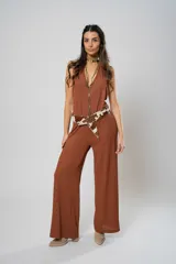 Mono largo color marrón, de tela de punto, con escote halter y corte palazzo. Incluye cinturón con estampado animal print.