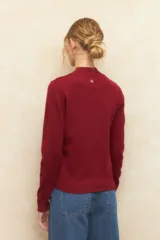 Polera color borgoña de tejido de punto con cuello alto y mangas largas.