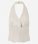 Chaleco color crudo confeccionado en viscolino, con escote halter, cierre frontal con botones, bolsillos delanteros falsos y bajo en V.
