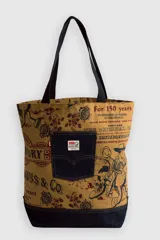 Bolso tipo shopper de tela color caqui con estampado integral de temática western y floral, con detalles de personajes de Toy Story. Presenta un bolsillo exterior de jean oscuro con el clásico diseño de bolsillo trasero de Levi's y etiqueta con logos de Levi's y Pixar.