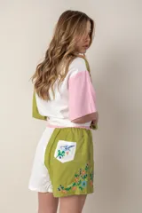 Short de lino color verde con bordados de flores en el ruedo y bolsillo trasero.