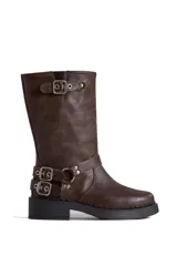 Borcego de cuero color marrón con apliques plateados, caña alta y suela track.