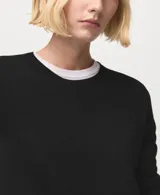 Jersey de punto fino color negro, de corte recto, con cuello redondo y manga larga.