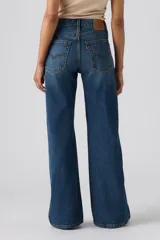 Jeans de denim azul de corte amplio y bota ancha, tiro medio, con efecto ligeramente lavado en las piernas y diseño clásico de cinco bolsillos.