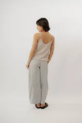 Musculosa negra con escote en V, breteles finos regulables y doble volado frontal con pespuntes.