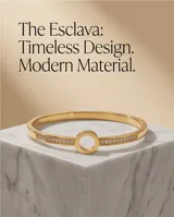 Esclava rígida de acero con baño de oro, con diseño central circular y engaste de circonias a lo largo de la banda.