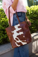 Bolso tote de cuero marrón con panel central de cuero con estampado animal print de vaca.